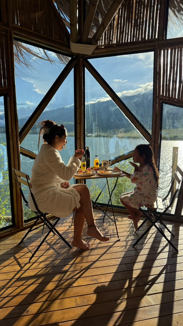 Huéspedes disfrutando su desayuno junto a los ventanales con vista al Lago Calima